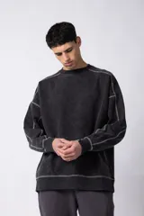 Buzo negro de frisa 100% algodón, con calce oversize y lavado gastado. Tiene costuras a contratono y recortes.