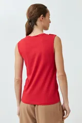 Musculosa roja de algodón con cuello redondo y botones decorativos en los hombros.