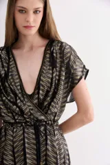 Vestido corto con escote cruzado en V y manga corta, confeccionado en tul con tejido de rayas doradas y negras. Presenta un lazo para ajustar la cintura y un viso interior con breteles regulables.