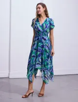 Vestido midi de gasa estampada con motivos florales en tonos azules y verdes. Escote en V tanto en la parte delantera como en la espalda. Corte en la cintura con punto smock y ruedo asimétrico.