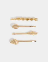 Set de cuatro horquillas doradas para el pelo con diseño de conchas marinas.