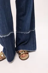 Pantalón de jean crudo, de corte recto y tiro bajo, con doble pasacinto y ajuste con lazo.