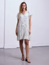 Vestido corto estampado, marca Marissa Olivia. Cuello a la base con frunce y lazo de ajuste. Terminación de ruedo con volado. Forro interno a tono.