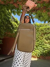 Bandolera compacta de símil cuero color rojo, con correa regulable y desmontable. Posee apertura superior, bolsillo frontal con cierre y bolsillo trasero abierto.