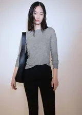 Camiseta gris de punto con cuello barco y manga larga.