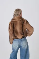 Campera de piel sintética color tostado con cuello clásico, cierre frontal de cremallera y terminaciones elásticas en puños y cintura.