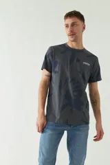 Remera gris con estampado floral azul y logo Mistral en el pecho.