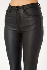 Pantalón jean engomado negro, de corte skinny y tiro medio.