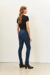 Jean slim de denim azul con lavado localizado y detalles de hot fix en los bolsillos delanteros.