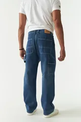 Pantalón jean celeste de corte amplio, estilo carpenter, con bolsillos laterales y logo bordado.