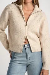 Cardigan de punto color beige melange con textura tweed, cuello alto y cierre frontal metálico. Corte ajustado al cuerpo y manga larga.