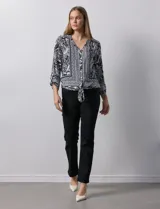 Blusa estampada con escote en V y abertura con botones. Largo de manga regulable con presilla y botón. Terminación de ruedo con nudo.