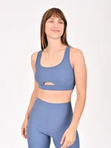 Top deportivo azul con escote redondo y abertura en el centro del pecho.