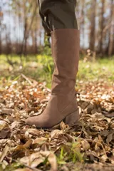 Bota de cuero color marrón claro, de caña alta y taco cuadrado.