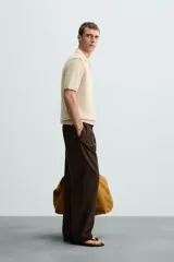 Polo color beige de punto con cuello solapa y manga corta.