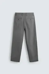Pantalón chino color beige, de corte recto y tiro medio. Confeccionado en tejido de algodón con elasticidad, con bolsillos laterales y traseros de vivo. Cierre frontal con cremallera y botón.
