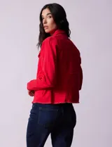 Campera de jean blanca, marca Baccini, con cuello solapa, bolsillos delanteros, abertura central con botones metálicos y terminación desflecada en el ruedo.