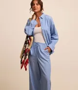 Pantalón de tricolina con estampado de rayas verticales, corte wide leg, elástico y lazo en la cintura.