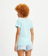 Blusa blanca de algodón con cuello en V, manga corta y bolsillo frontal.
