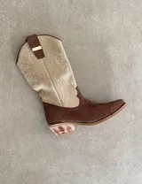 Botas de cuero negro con bordado decorativo en el caño y empeine, taco bajo y punta fina. Diseño de estilo cowboy.