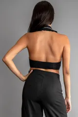Top halter negro con cuello grande estilo solapa con borde de perlas sintéticas y cierre con botones en el frente.