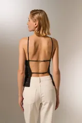 Top negro ajustado al cuerpo, de poliéster, con cuello recto y cuentas decorativas.