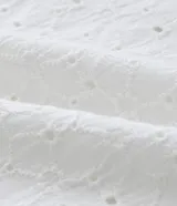 Camisa de hombre de calce holgado (comfort), confeccionada en algodón con técnica laise que incluye perforaciones florales cortadas con láser. Cuenta con cuello tipo solapa, manga corta y cierre frontal con botones al tono.