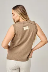 Chaleco de punto calado color blanco, con cuello redondo y sisas anchas.