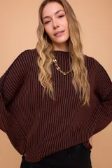 Buzo color crema tejido en algodón, de silueta holgada, mangas anchas y cuello bote.