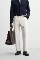 Pantalón chino negro slim fit confeccionado en tejido técnico de secado rápido. Cuenta con bolsillos frontales y traseros de vivo. Cierre frontal con cremallera y botón.