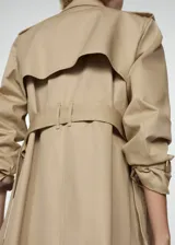 Trench coat negro con cuello de solapa, doble botonadura, trabillas en los puños, cinturón ajustable y abertura posterior en el bajo.