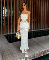 Vestido tejido strapless color blanco, con detalles calados y falda larga con flecos. Incluye short.