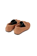 Mocasín color caramelo de cuero gamuzado con lazo frontal y detalle de pasacintas laterales. Suela flexible antideslizante.