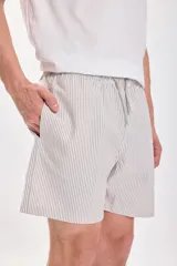 Short de baño corto con rayas verticales en tonos beige y blanco, con cintura elástica ajustable con cordón.