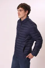 Campera puffer color verde militar, con cuello alto y cierre frontal. Diseño acolchado horizontal.