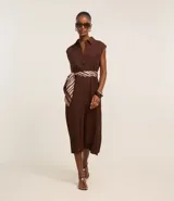 Vestido chemise de lino color negro, con cuello camisero, sin mangas y cierre frontal con botones. Incluye cinturón de tela estampado.