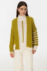 Saco color crudo con detalles en negro, tejido de punto estilo relajado y corte amplio.