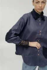 Camisa blanca de lino con cuello clásico, cierre frontal con botones y manga larga. Presenta detalles de crochet en cuello, puños y bolsillo.