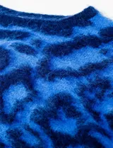 Buzo de lana con cuello redondo, manga larga amplia y corte crop. Presenta un estampado animal print en tonos de azul vibrante.
