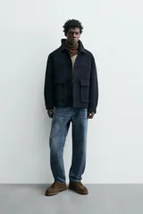 Pantalón de jean azul de corte recto, con cinco bolsillos, efecto lavado y cierre frontal con botones.