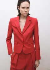 Blazer rojo de corte entallado, con cuello de solapa de muesca, cierre frontal con dos botones y bolsillos de solapa.
