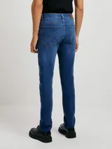 Pantalón de jean negro, corte ajustado (skinny), con tiro medio y cierre de botón y cremallera.