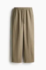Pantalón tobillero color beige de corte holgado en tejido liviano de mezcla de lino. Modelo de tiro alto con elástico revestido y cordón para ajustar fino en la cintura, bolsillos al bies y piernas ajustadas.