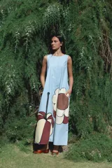 Vestido largo marrón con estampado de flores rosas, sin mangas y corte holgado.