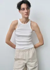 Musculosa blanca de algodón con textura acanalada, cuello redondo y corte ajustado.
