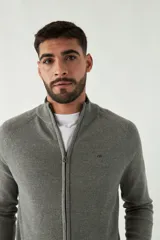 Campera tejida azul marino con cuello alto, cierre frontal y puños acanalados con detalle de línea roja.