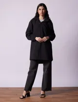 Gabardina negra impermeable con capucha desmontable, cierre central con cremallera y botones a presión, bolsillos delanteros y forro interno.