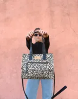 Cartera bandolera Shill Mini de cuero con estampado animal print, forro de tela y correa larga negra regulable. Cuenta con bolsillo frontal con cierre y bolsillo interno. Fabricación nacional.