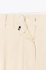 Pantalón de vestir color crema, de tiro alto y pernera ancha, con pinzas delanteras, bolsillos frontales y falsos bolsillos de doble vivo en la espalda.