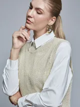 Chaleco de punto color beige con lurex, escote en V y sisas amplias.